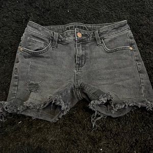 Black denim shorts with frae at the bottom.